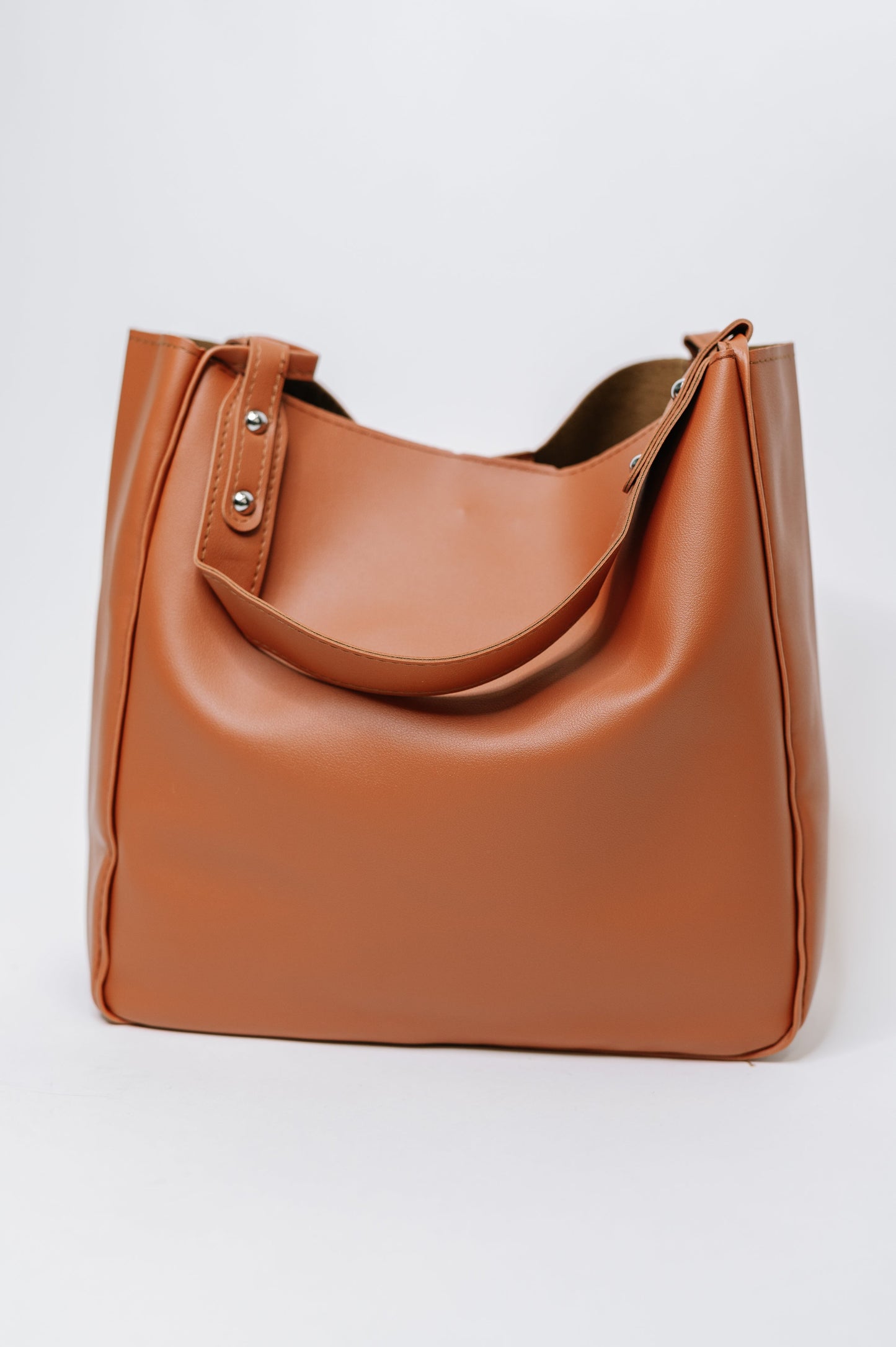 Brown leather handbag on a light gray background