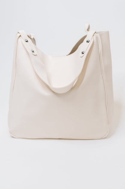 Beige tote bag with studded details on a white background