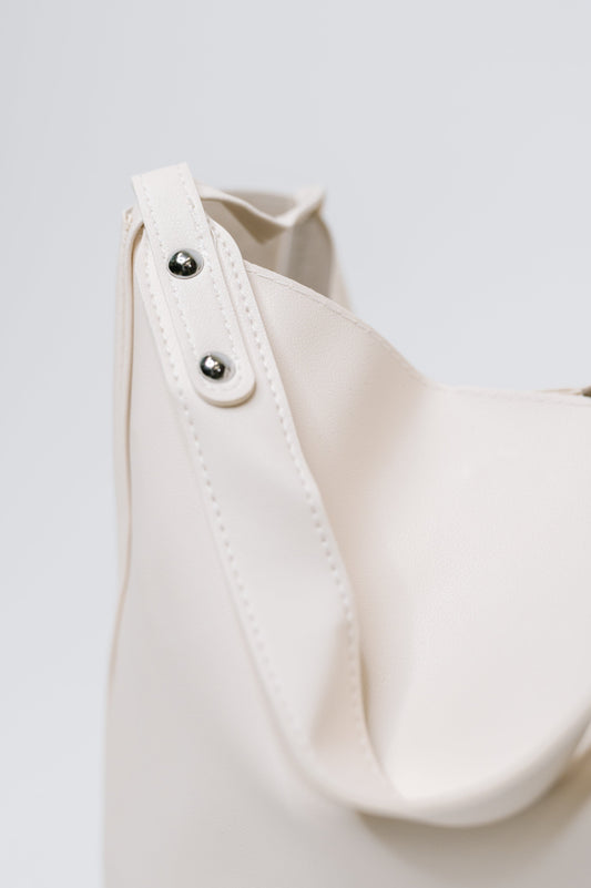 Close-up of a white bag with buttons on a light gray background