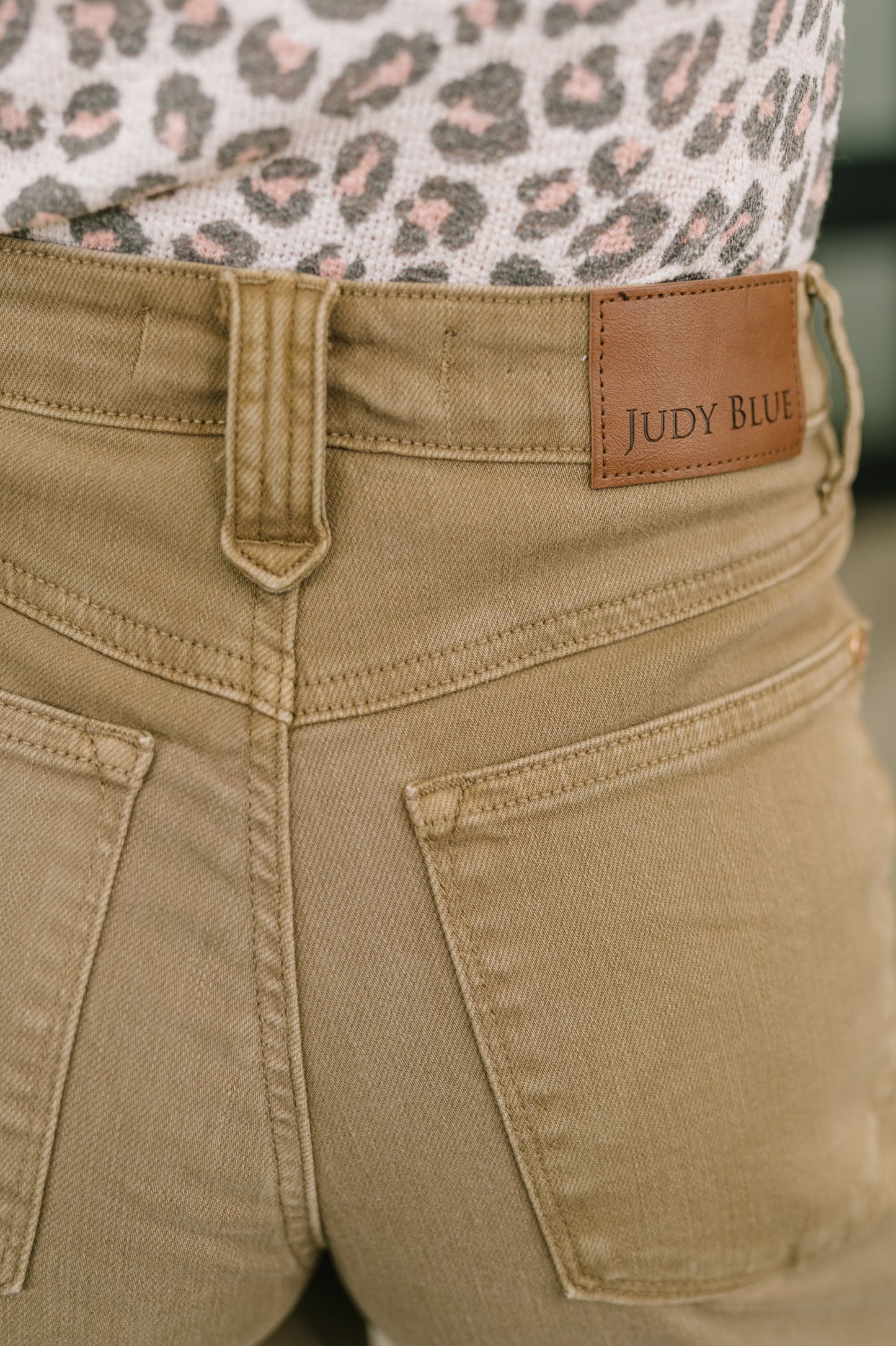 Close-up of beige pants with a brown label reading 'Judy Blue'.