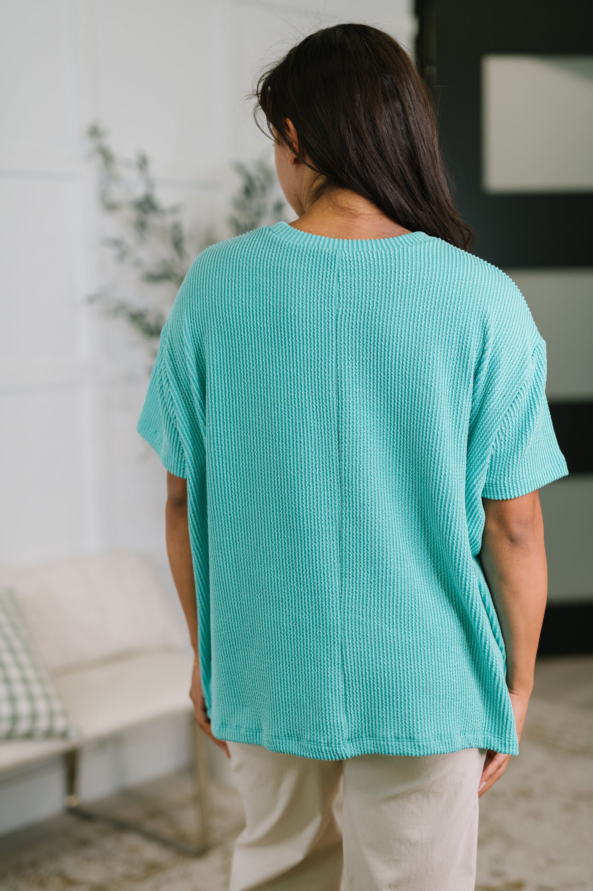 Person wearing a teal textured shirt in an indoor setting