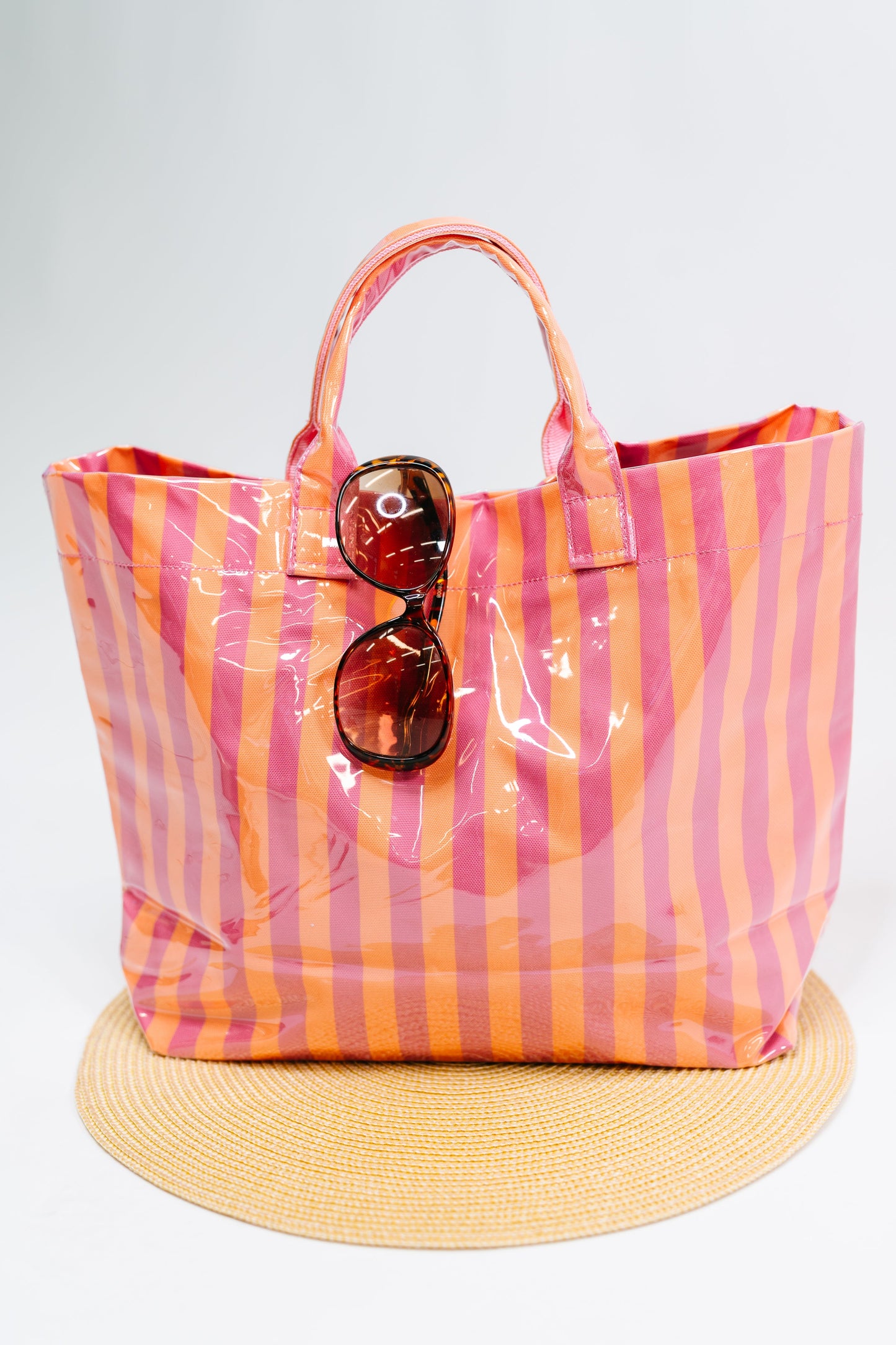 Striped tote bag with sunglasses on a white background
