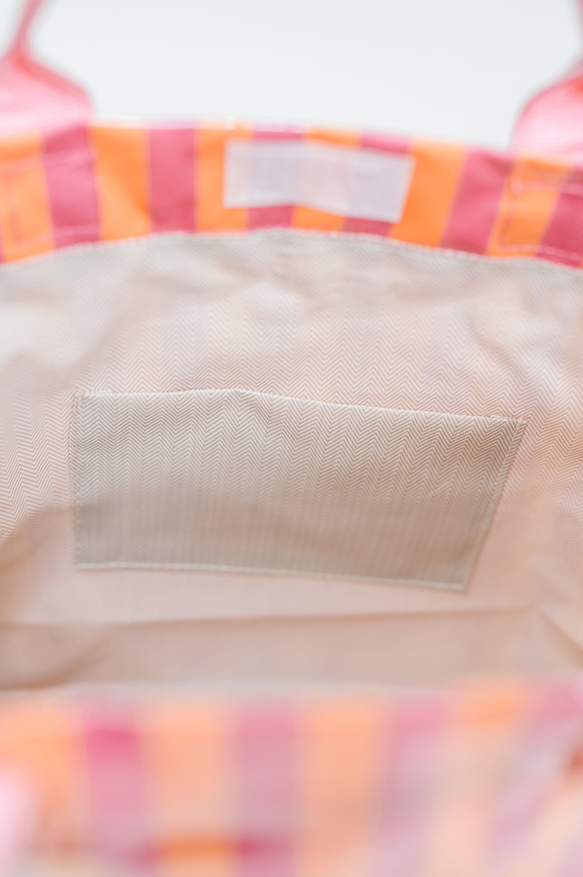 Close-up of a colorful striped fabric with a beige label.