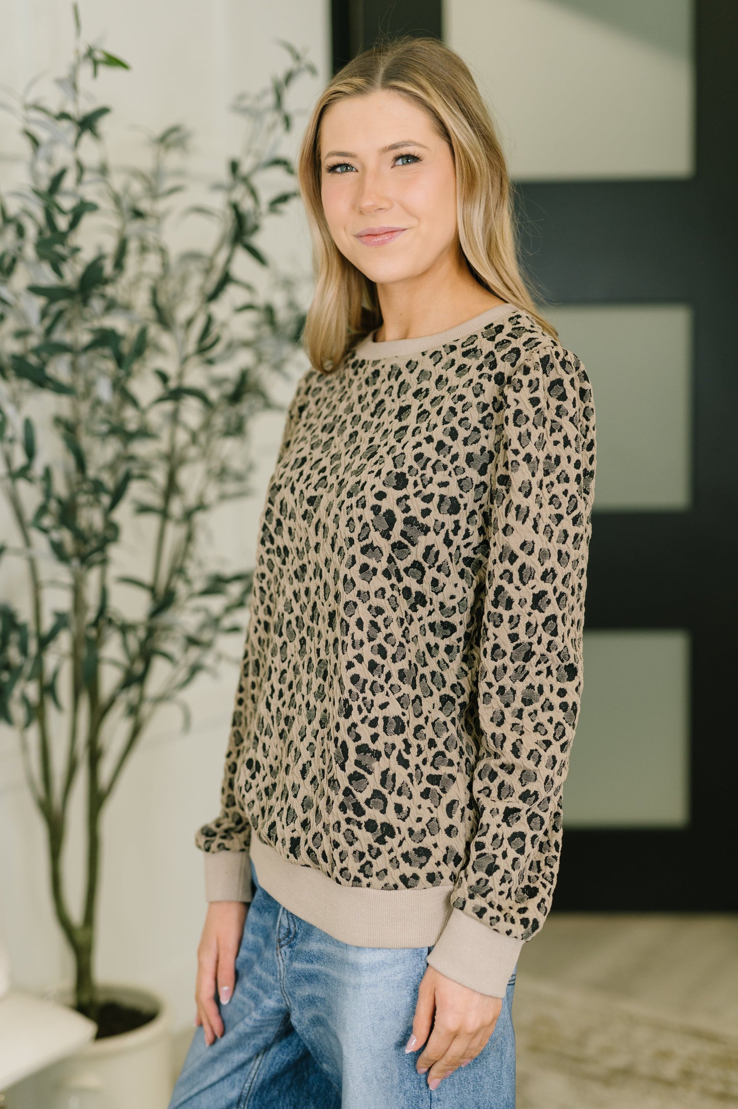 Woman wearing a leopard print sweater in an indoor setting