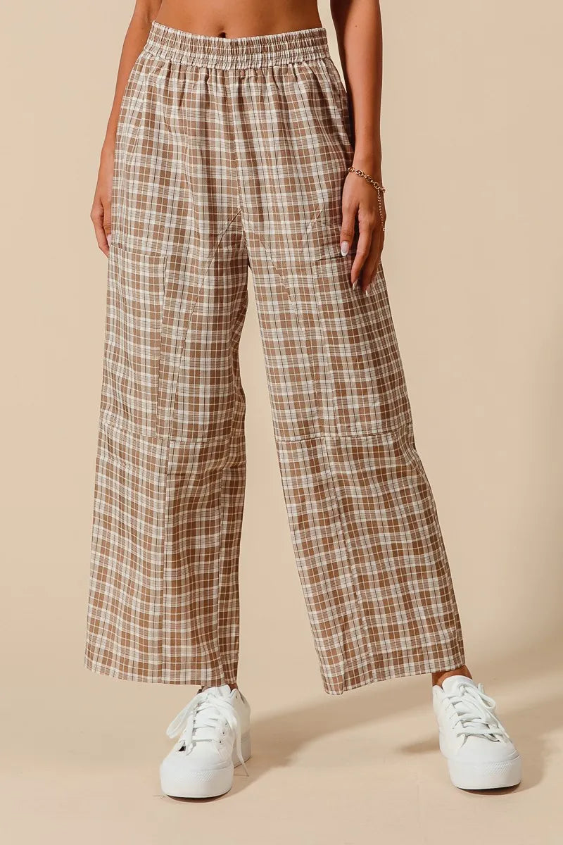 Plaid pants worn by a person on a beige background