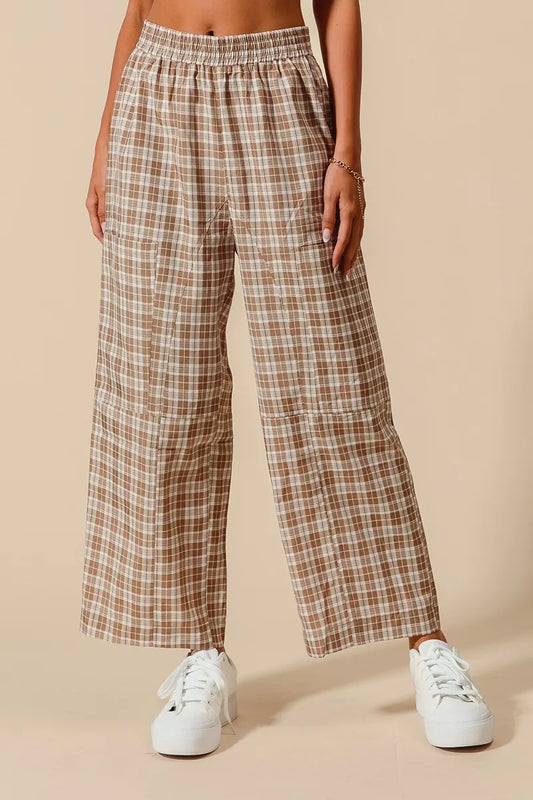 Plaid pants worn by a person on a beige background