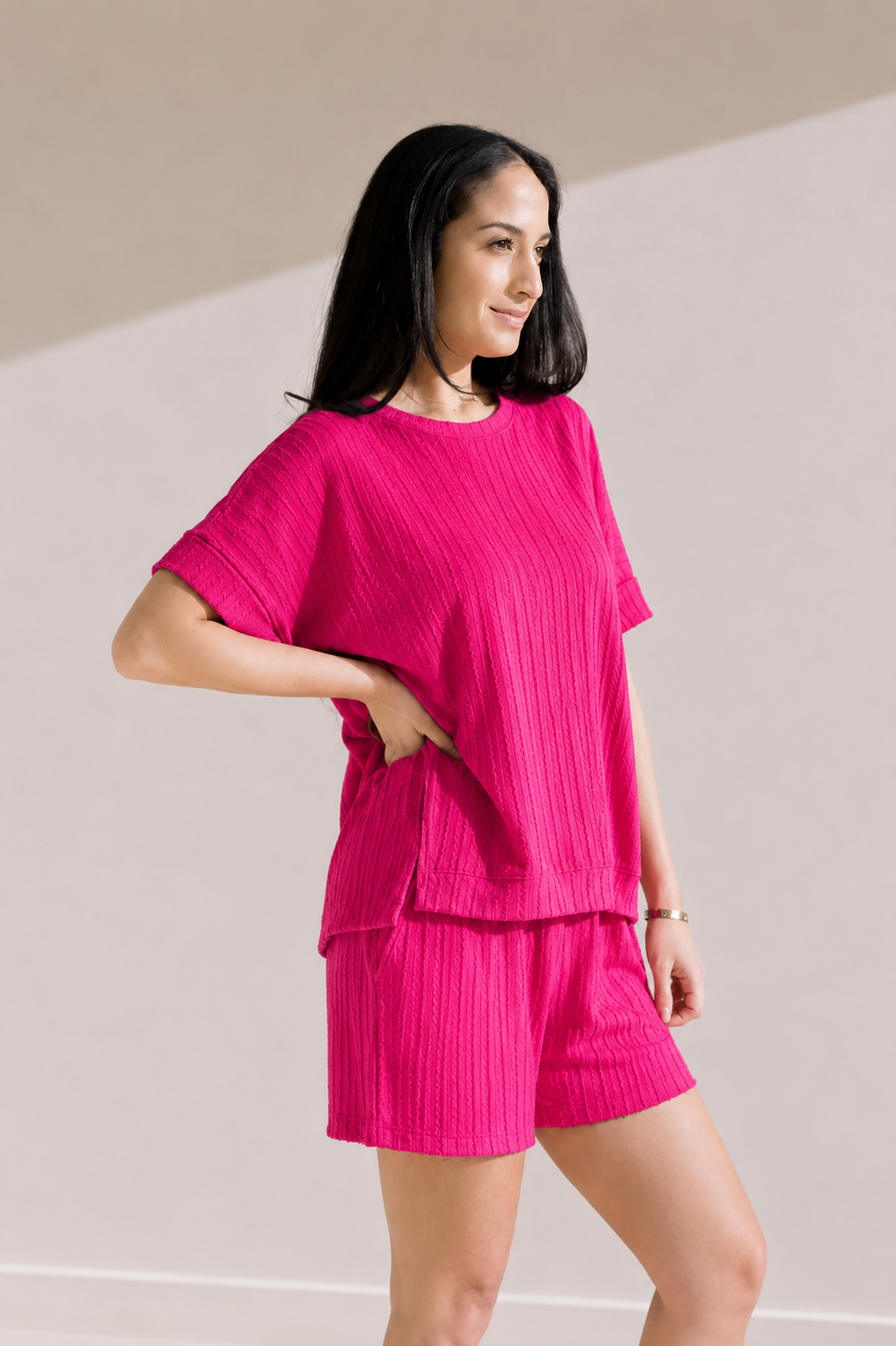 Woman wearing a bright pink outfit on a plain background