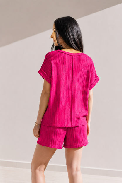 Woman wearing a pink outfit with a plain background
