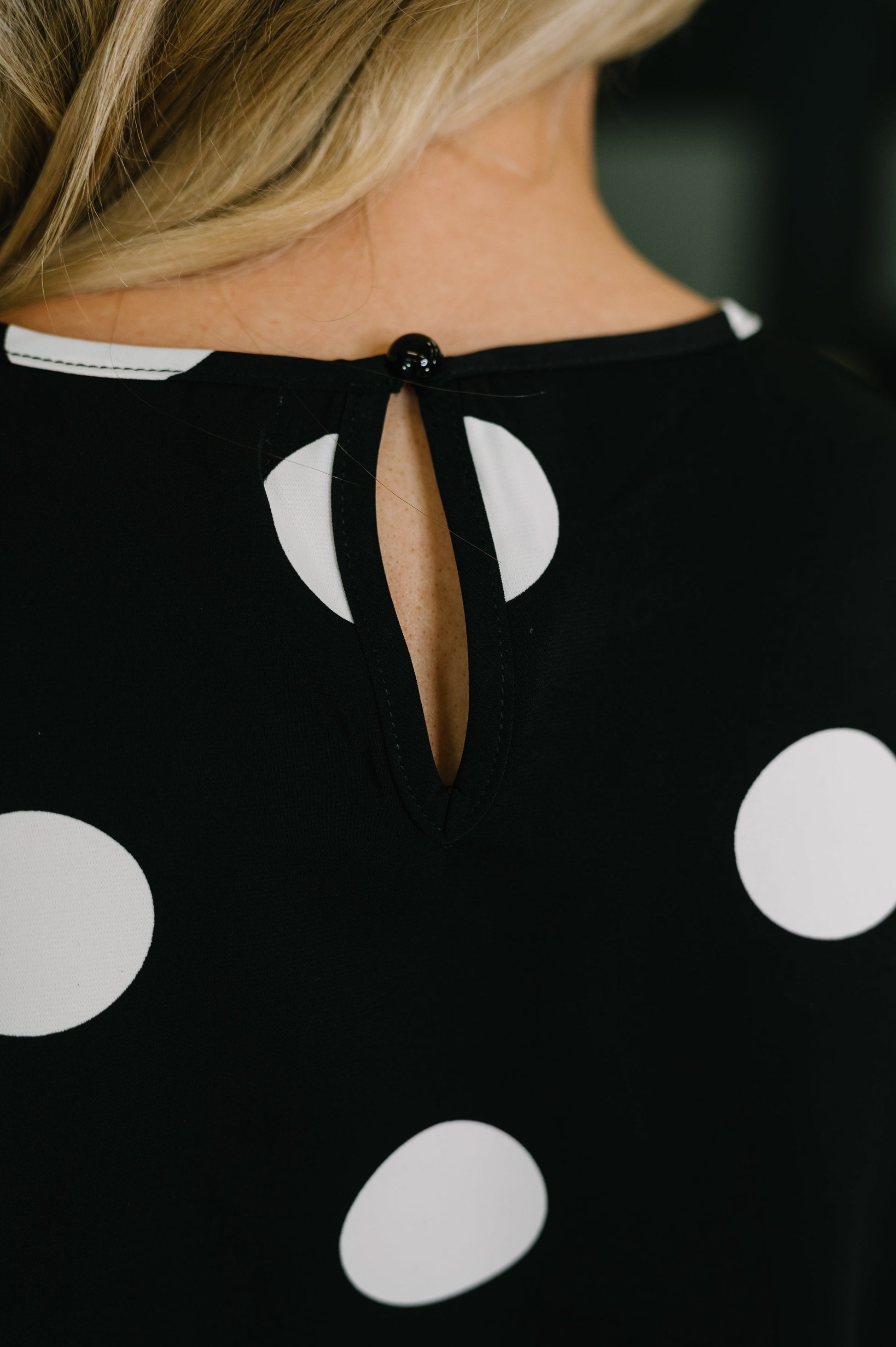 Black dress with white polka dots and a unique cutout design on the back.