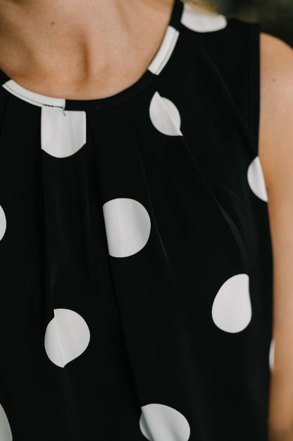 Black sleeveless top with white polka dot pattern