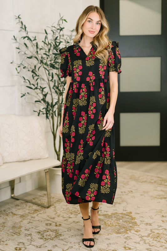 Woman wearing a black floral dress in an indoor setting