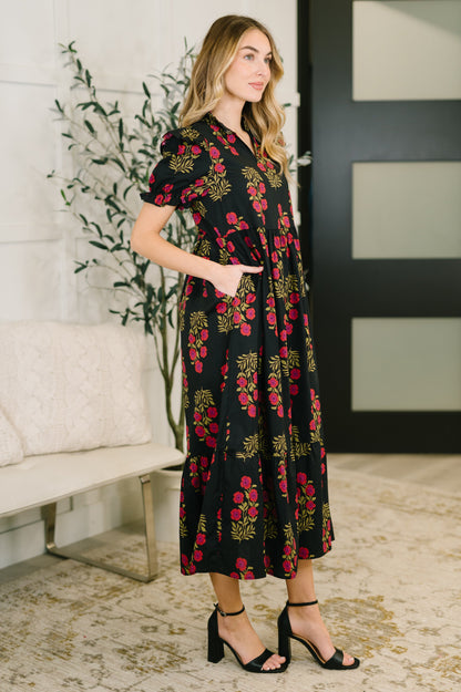 Woman wearing a black floral dress in an indoor setting