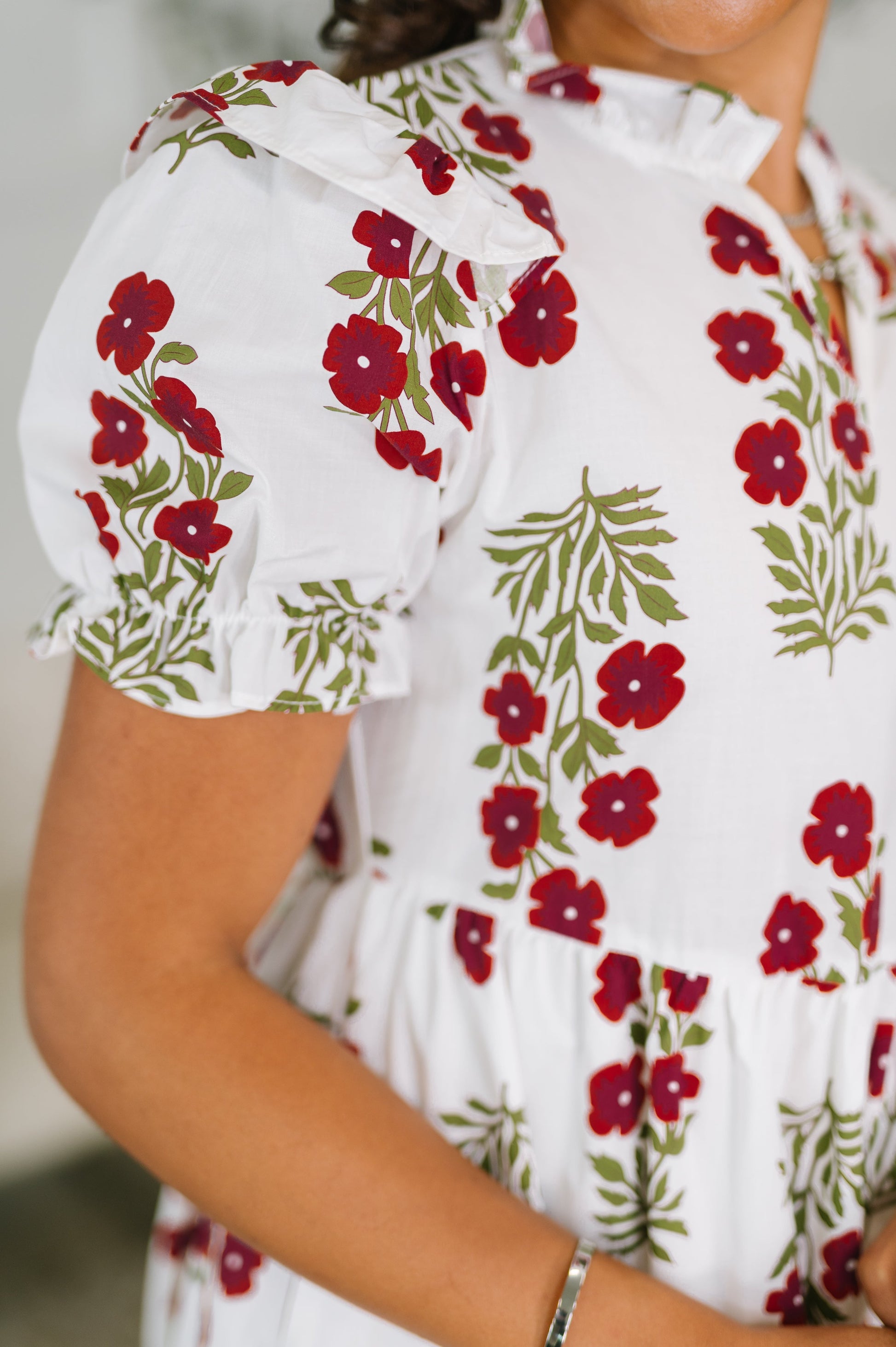 White blouse with red floral pattern worn by a person