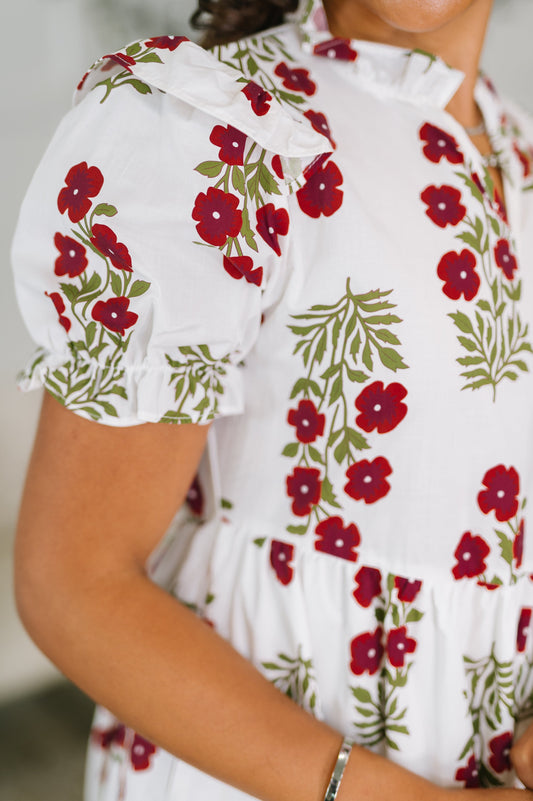 White blouse with red floral pattern worn by a person
