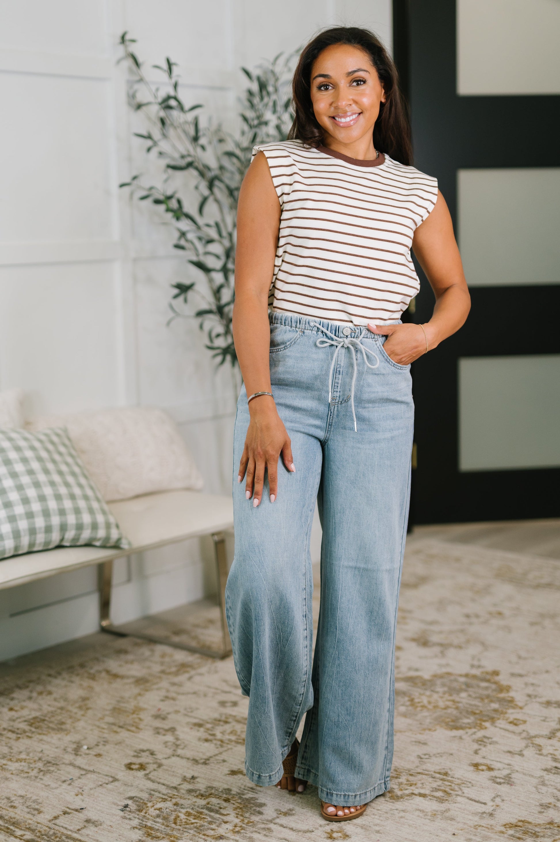 Woman wearing a striped top and jeans in a living room setting