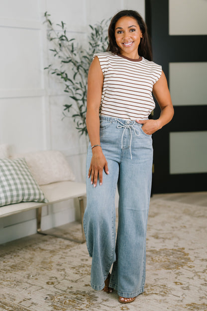 Woman wearing a striped top and jeans in a living room setting