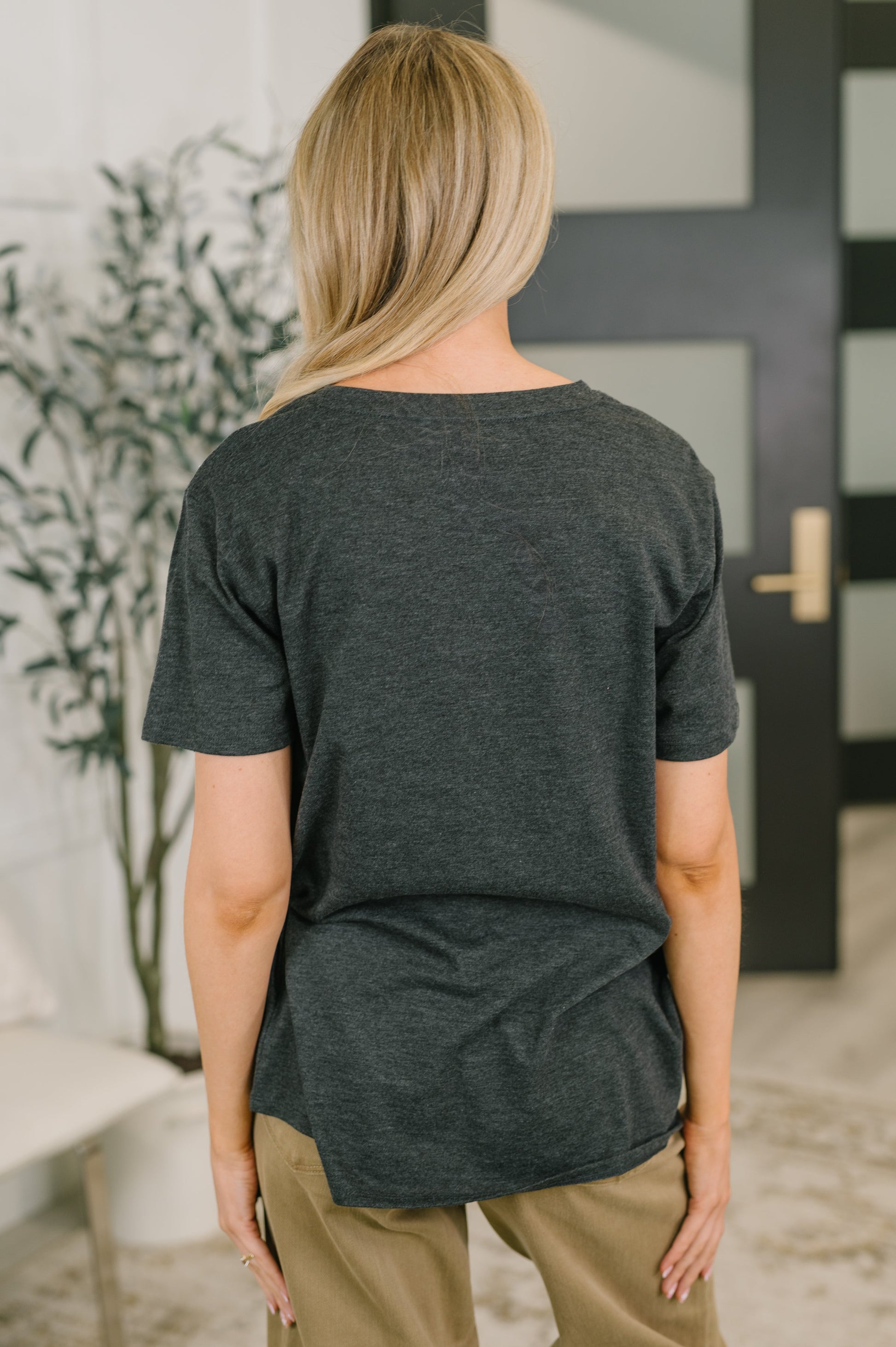 Person wearing a dark gray t-shirt in an indoor setting