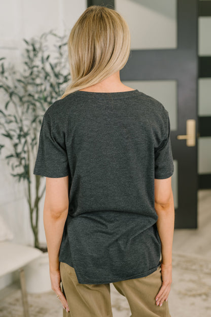 Person wearing a dark gray t-shirt in an indoor setting