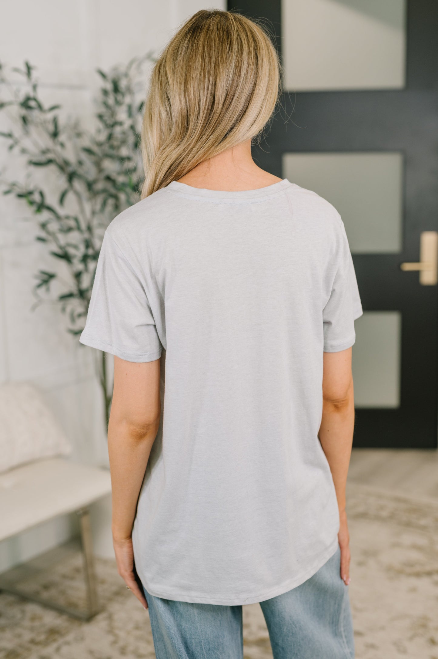 Person wearing a light gray t-shirt in an indoor setting