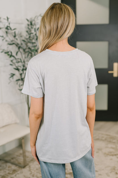 Person wearing a light gray t-shirt in an indoor setting