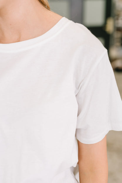 White t-shirt worn by a person with a blurred background