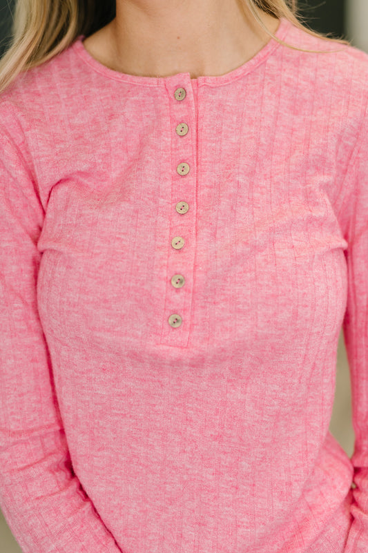 Close-up of a pink long-sleeve shirt with buttons on a blurred background