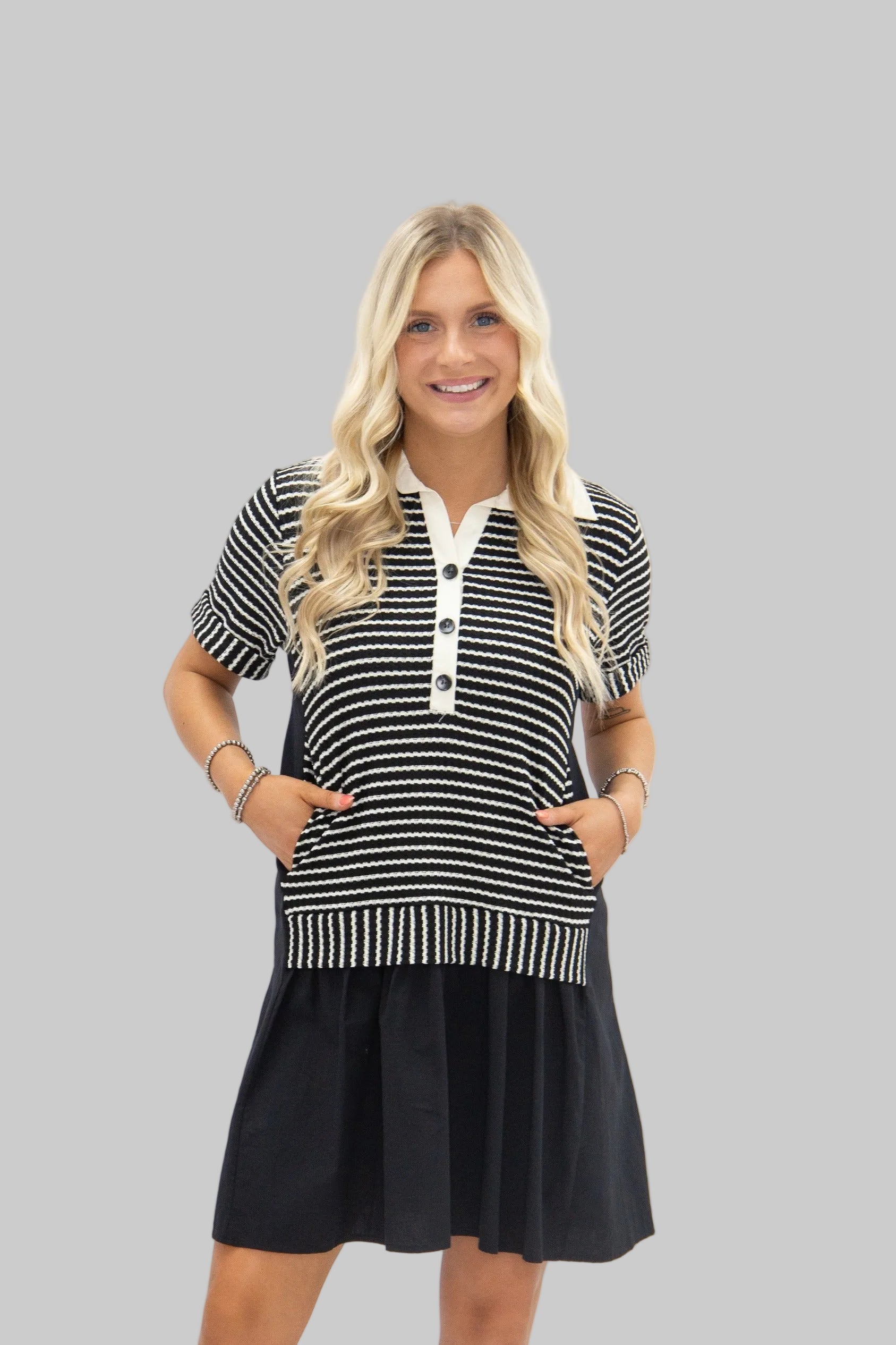 Woman wearing a black and white striped dress with a white collar on a white background