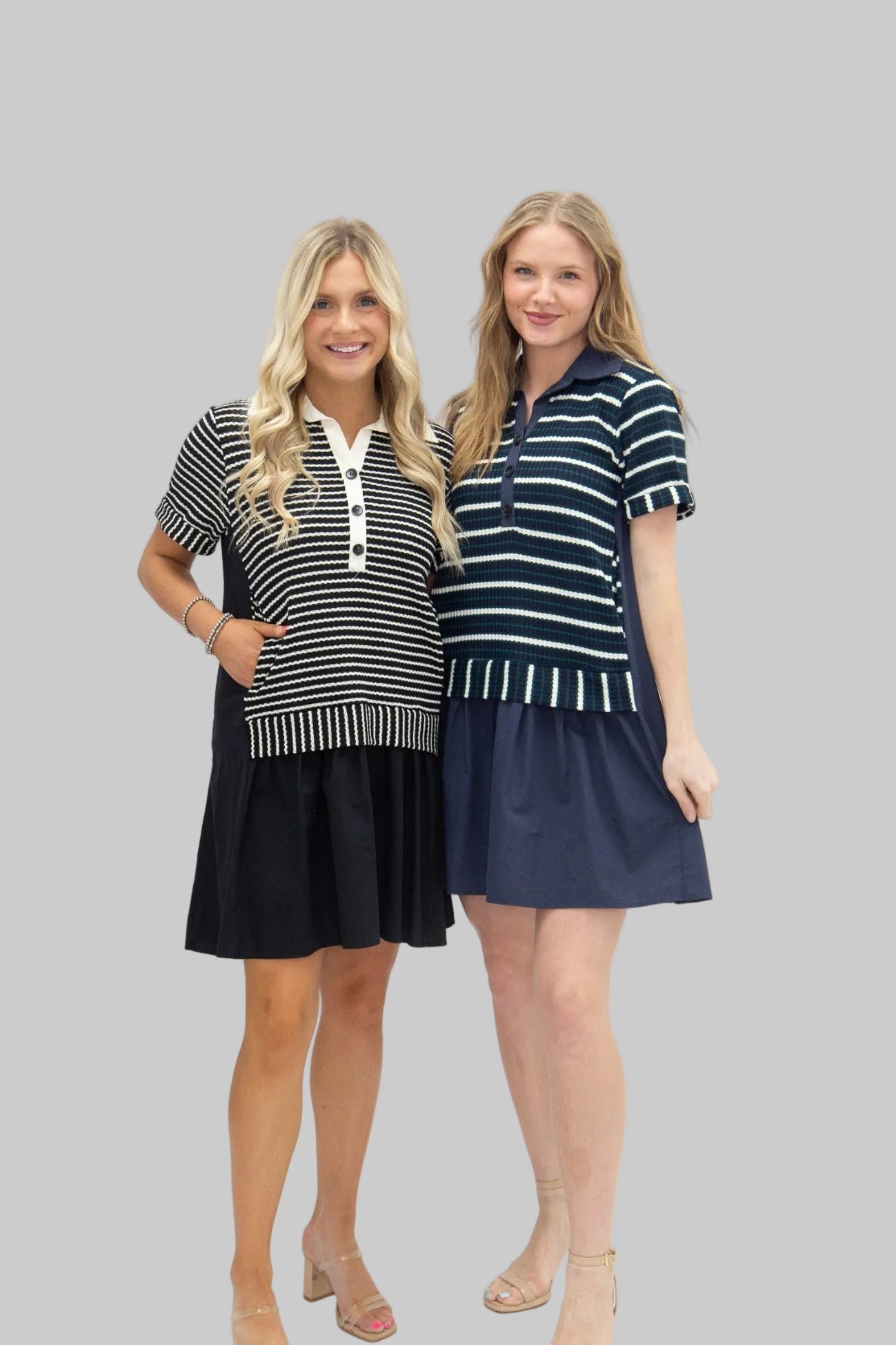 Two women wearing matching striped dresses on a white background