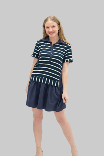Woman wearing a navy and white striped dress on a white background