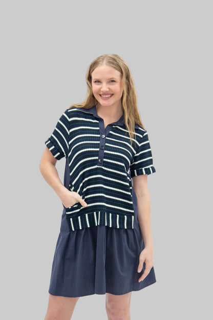 Woman wearing a navy and white striped dress on a white background