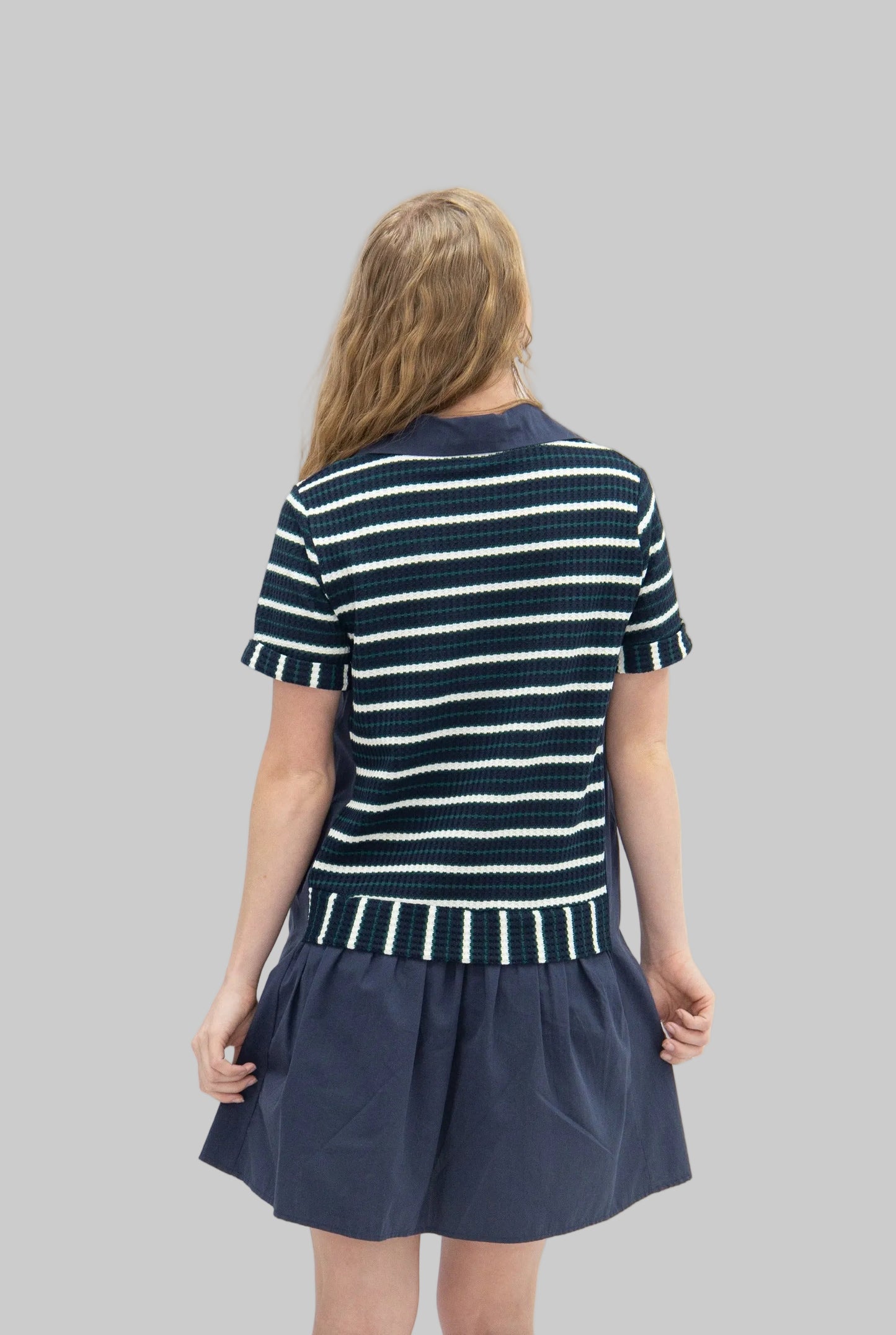 Woman wearing a navy and white striped dress on a white background