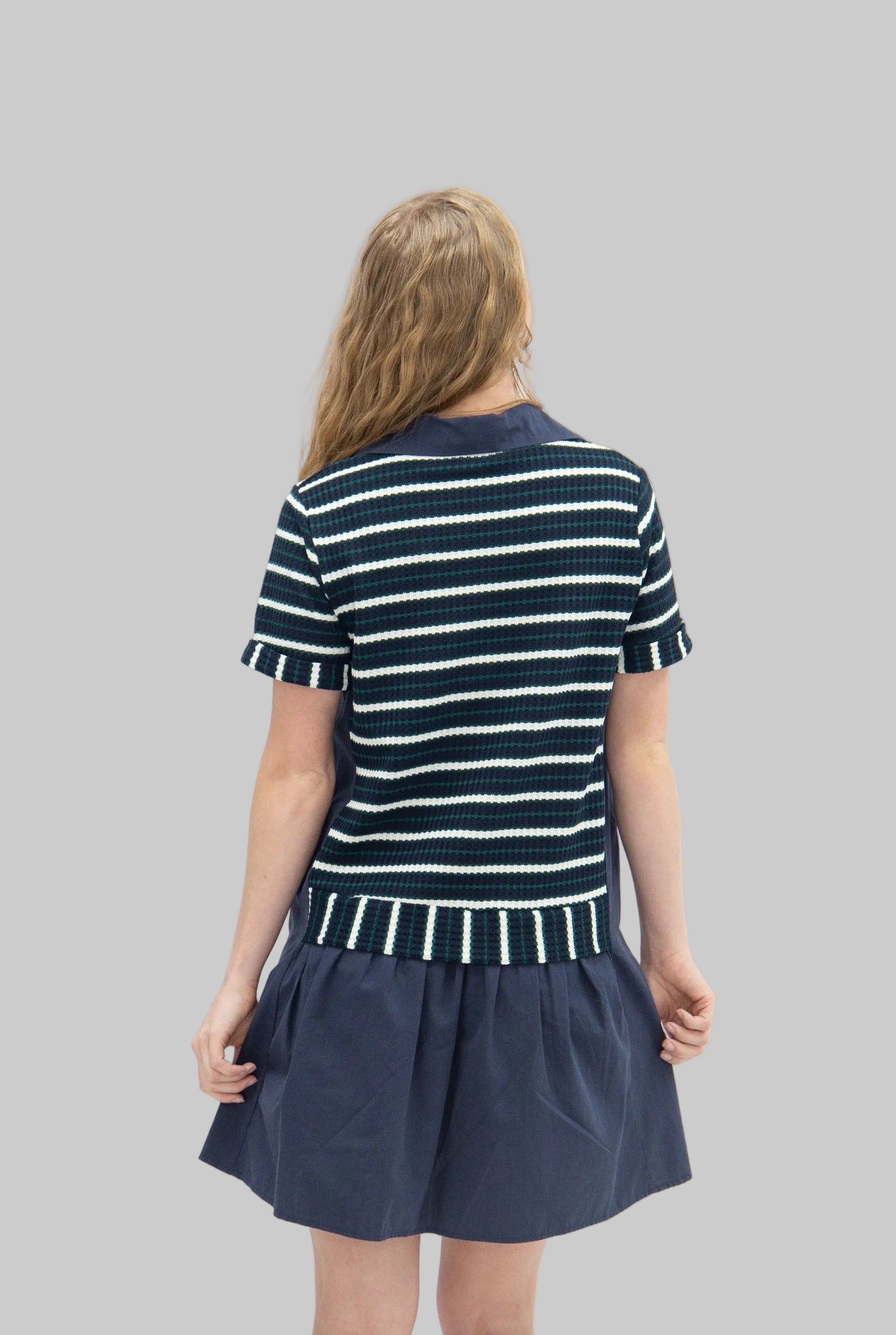 Woman wearing a navy and white striped dress on a white background
