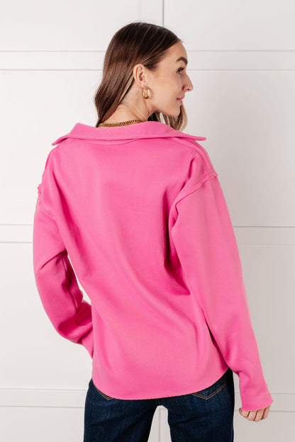 Woman wearing a bright pink jacket with a hood against a white background