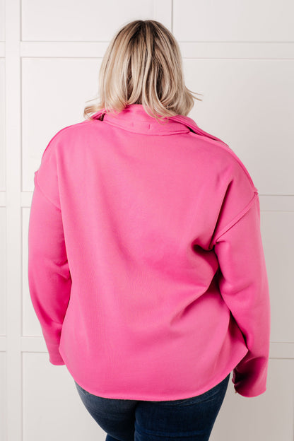 Person wearing a bright pink jacket in front of a tiled wall