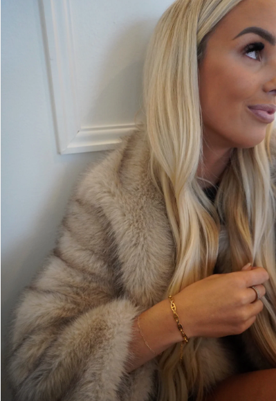 Woman wearing a fur coat with a neutral background