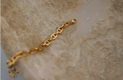 Gold bracelet on a marble surface