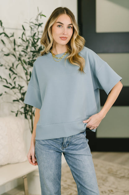 Woman wearing a light blue sweater and jeans in a home setting