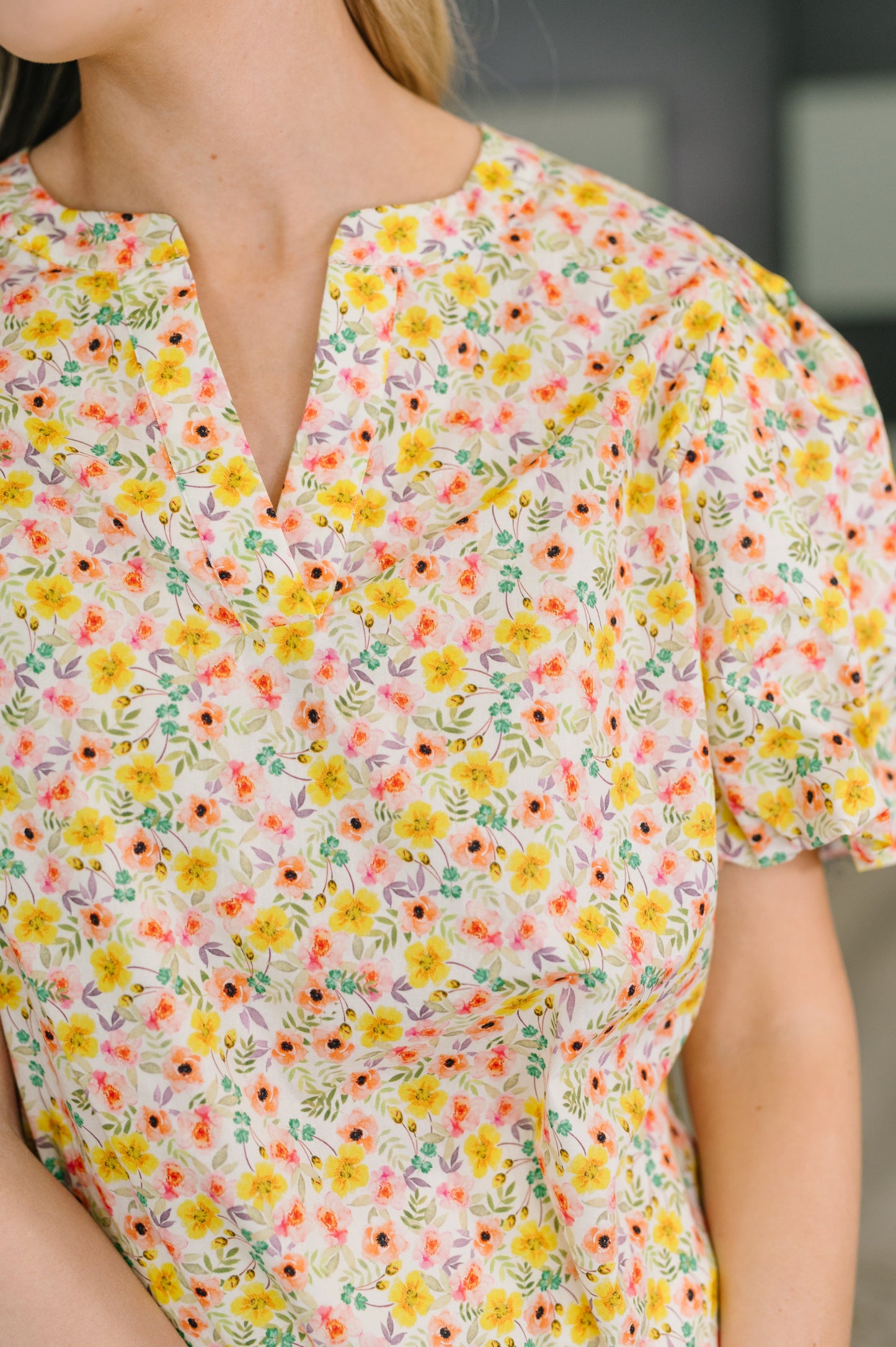 Woman wearing a floral blouse with a blurred background