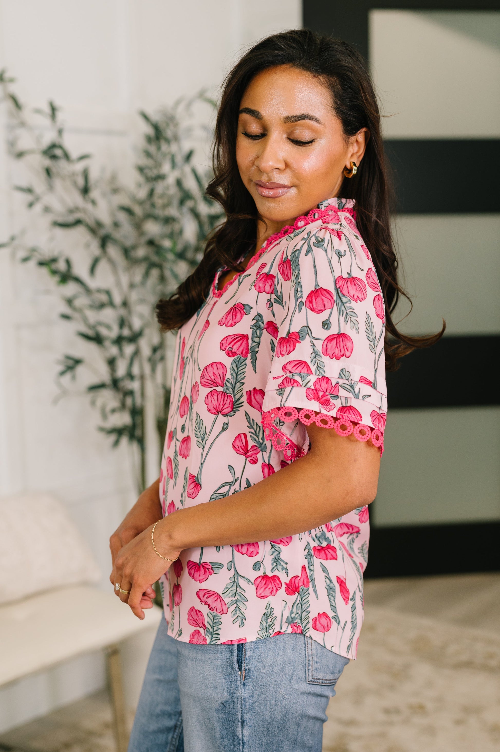 Woman wearing a pink floral blouse with a blurred background