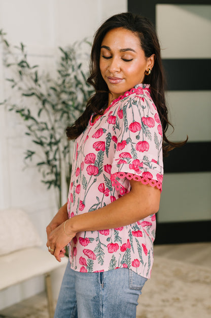 Woman wearing a pink floral blouse with a blurred background