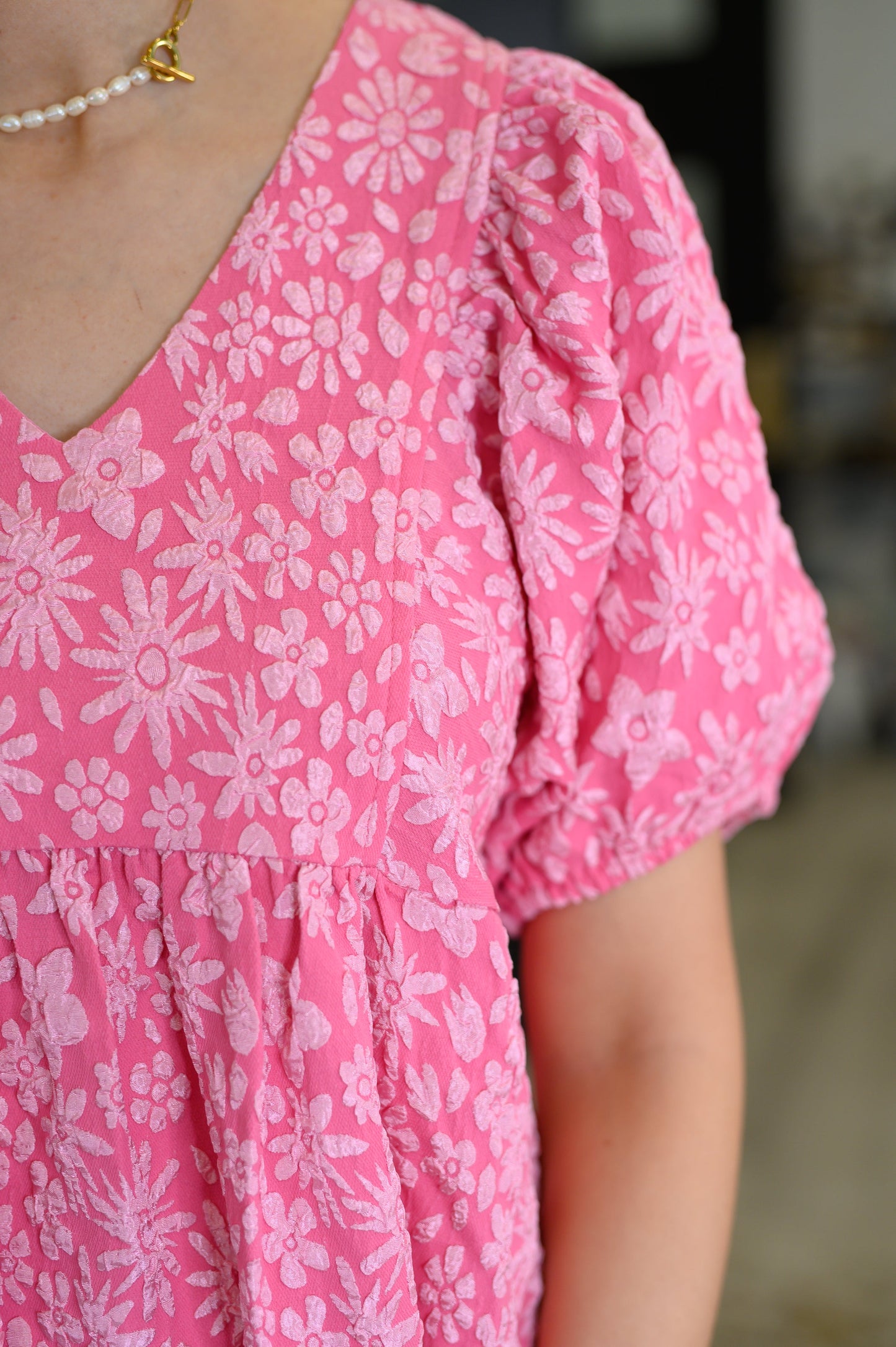 Close-up of a pink floral dress with puff sleeves.