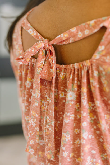 Floral dress with tied back detail on a blurred background