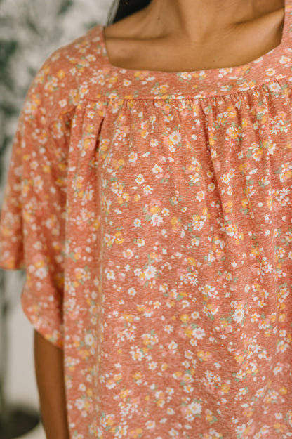 Close-up of a person wearing a floral dress with a blurred background