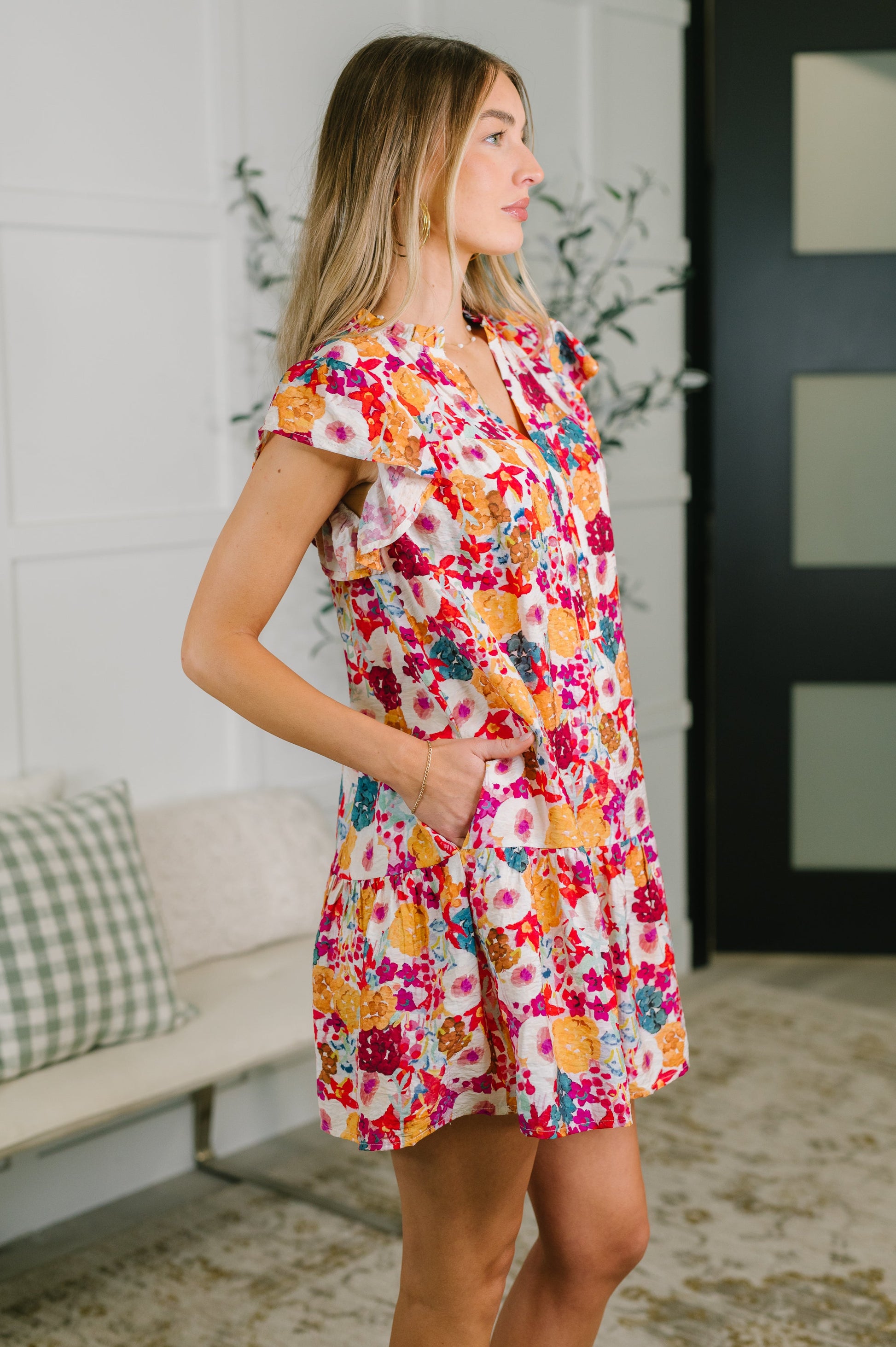 Woman wearing a colorful floral dress in an indoor setting