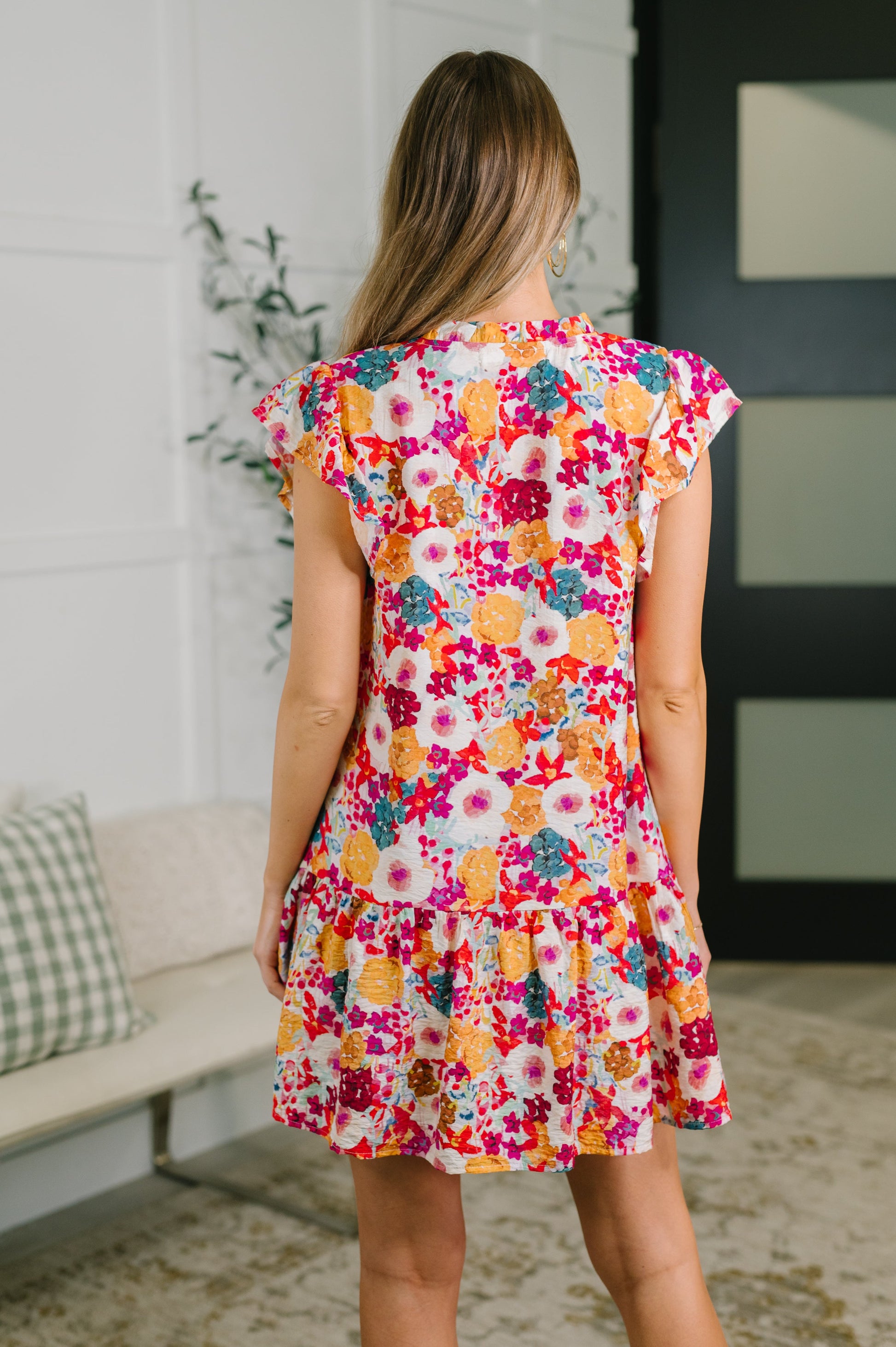 Woman wearing a colorful floral dress in an indoor setting