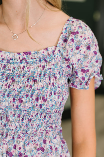 Close-up of a person wearing a floral dress with a blurred background