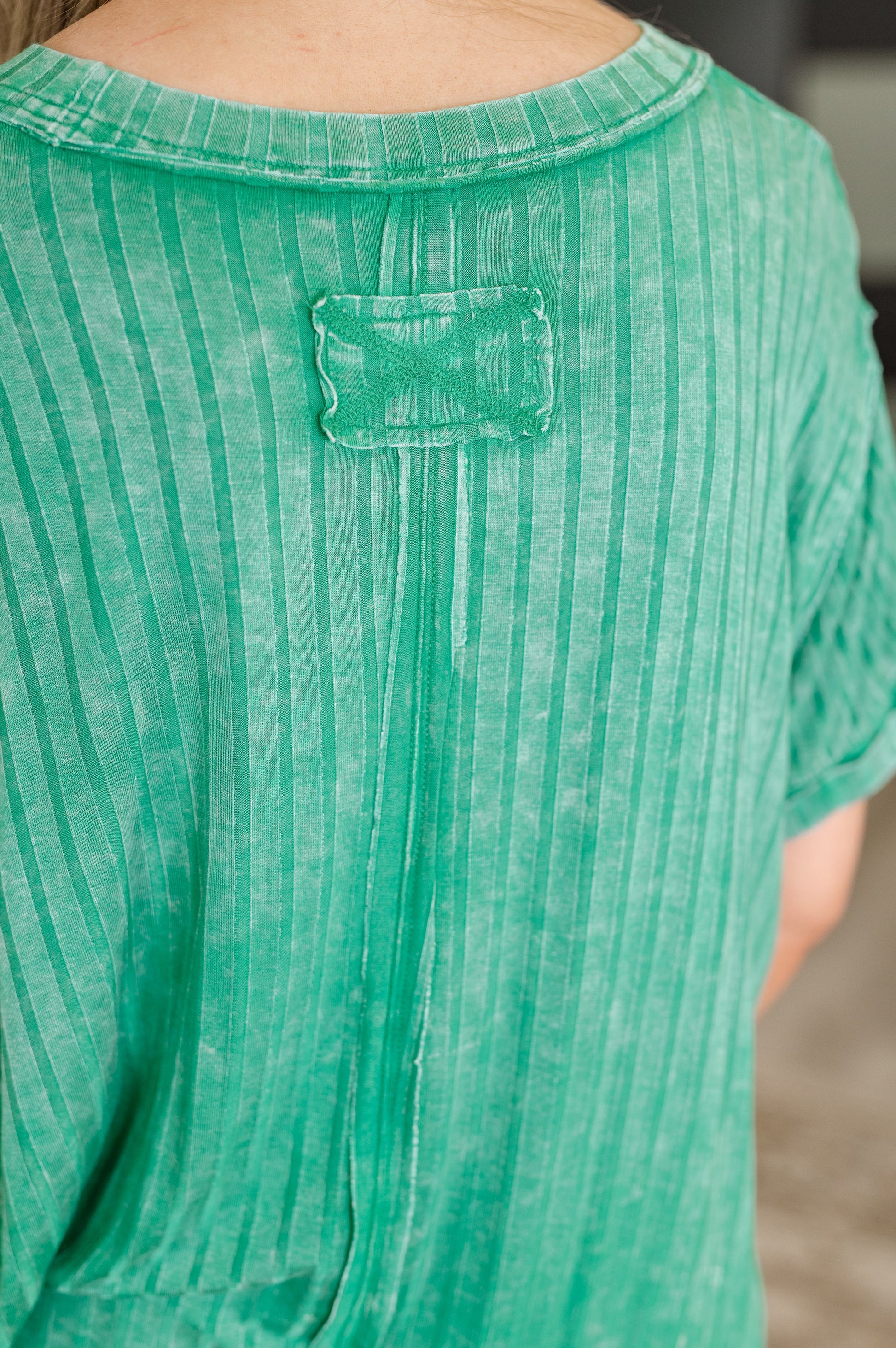 Close-up of a green textured shirt with a brand label.