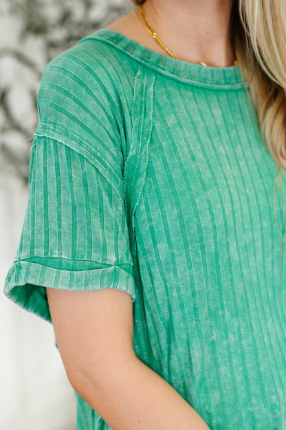 Green striped shirt worn by a person with a blurred background