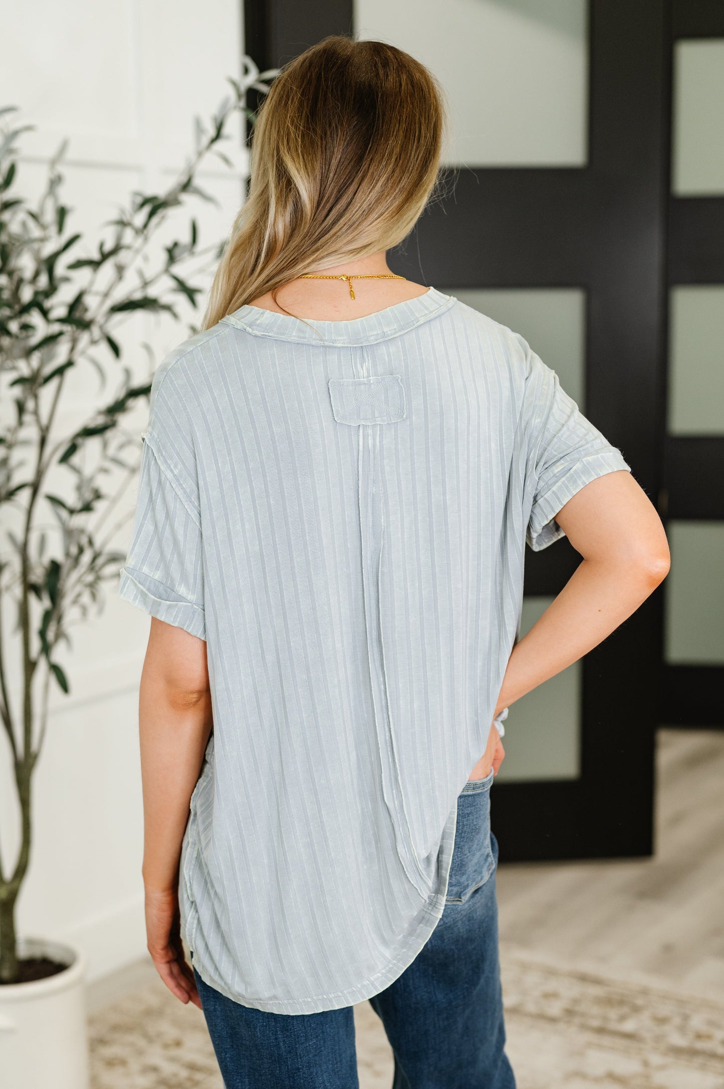 Woman wearing a light blue t-shirt and jeans in an indoor setting