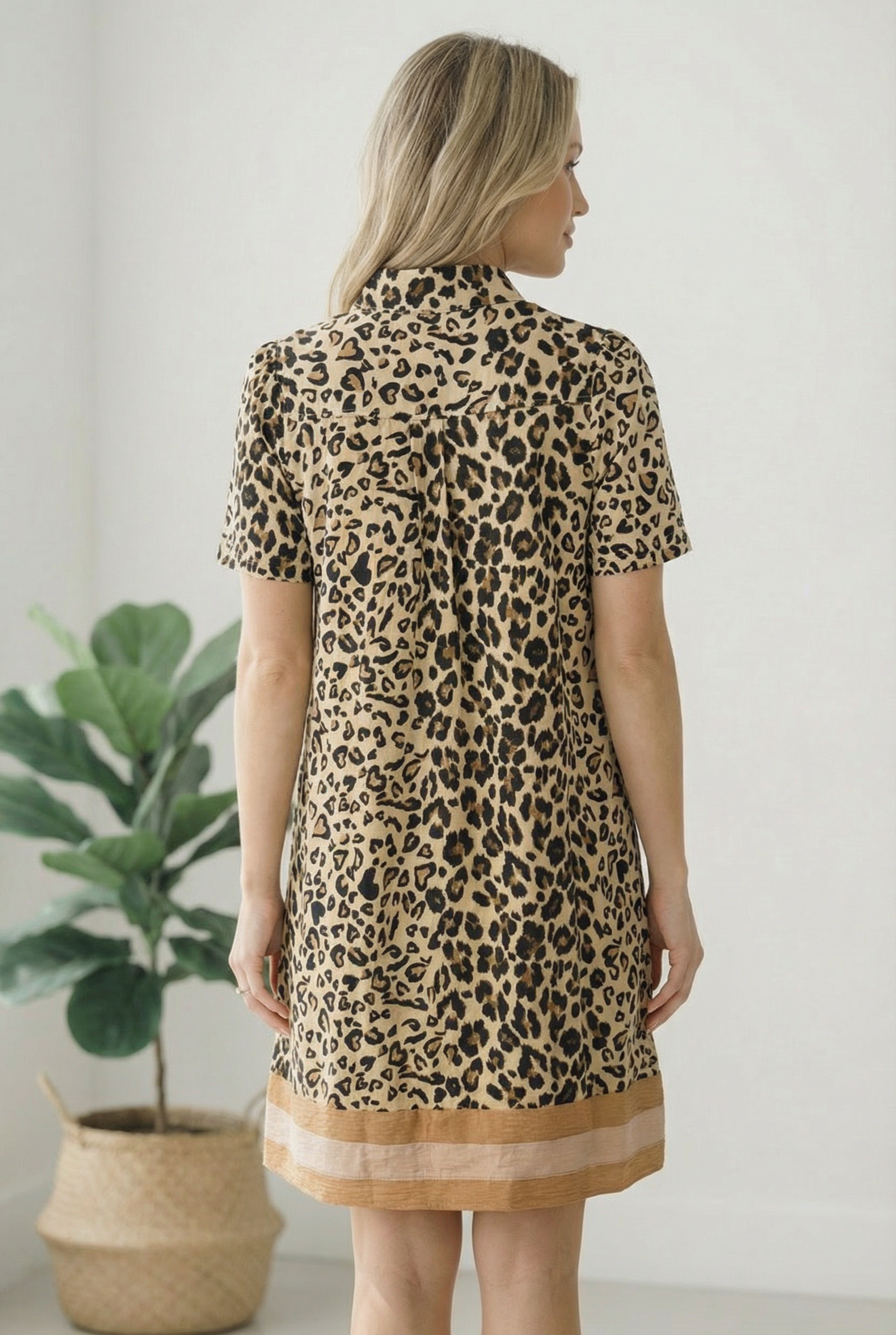 Woman wearing a leopard print dress with a plain background